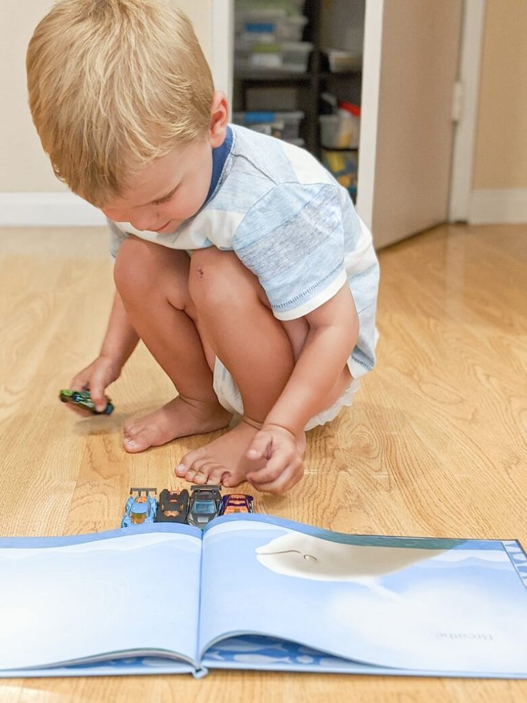 A child with his toy cars reading a mindfulness book for kids called Breathe