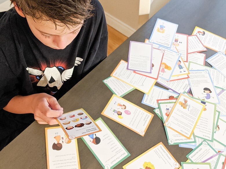 A boy reading mindfulness cards for kids
