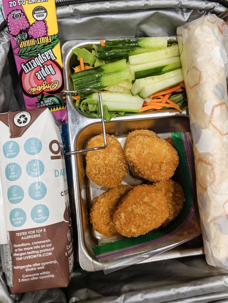 Vegan lunch for kids of chik'n nuggets, veggies, tortilla, fruit wrap and dairy-free chocolate milk