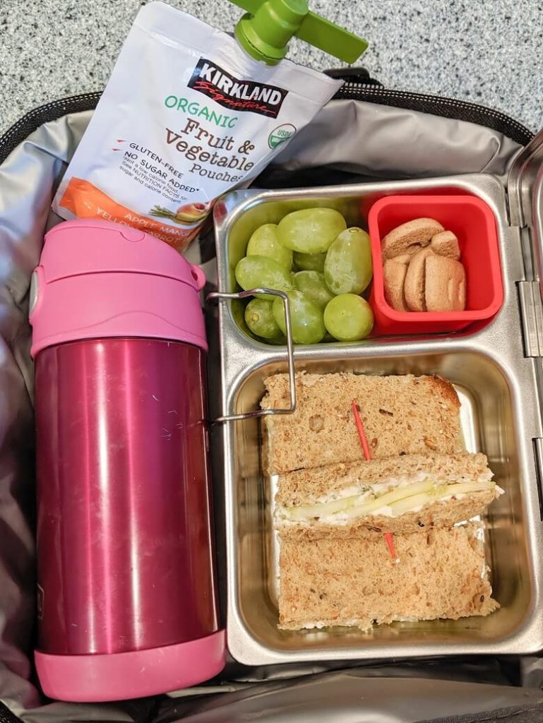 Quick vegan lunch for kids of cucumber sandwiches, grapes, graham crackers and fruit pouch
