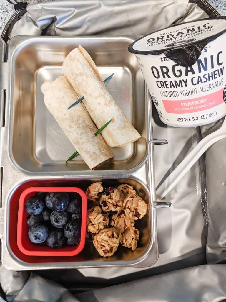Quick vegan lunch for school of vegan yogurt, nut butter roll-up, blueberries and granola minis