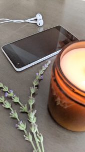 Candle, lavender a phone, and earbuds which are necessary to listen to EMDR music