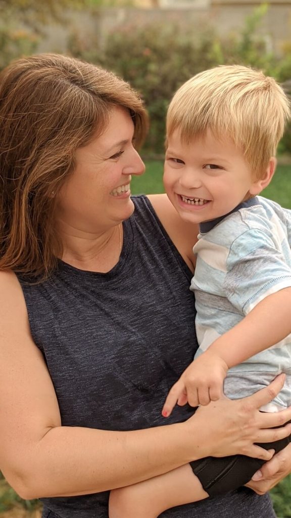 A mom holding her young son laughing, showing the emotional benefits of exercise.
