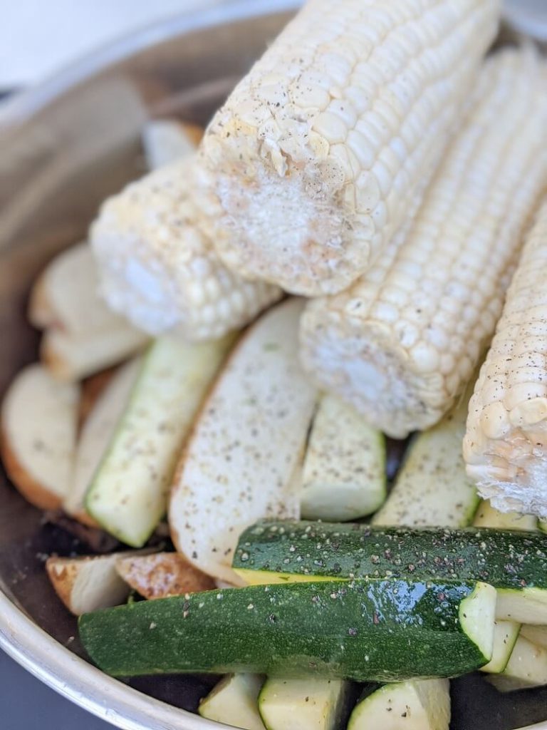 Vegan BBQ sides of corn, zucchini and potato in a bowl.