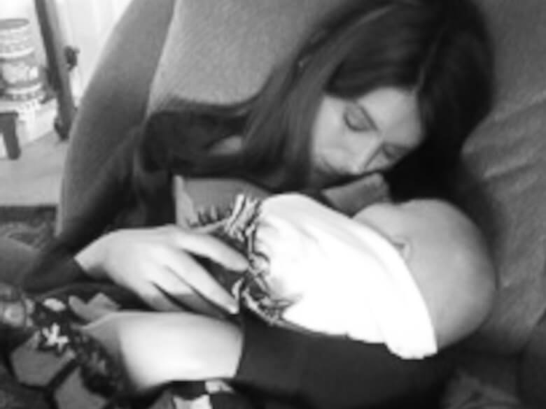 A stay-at-home mom holding her baby while they both sleep.