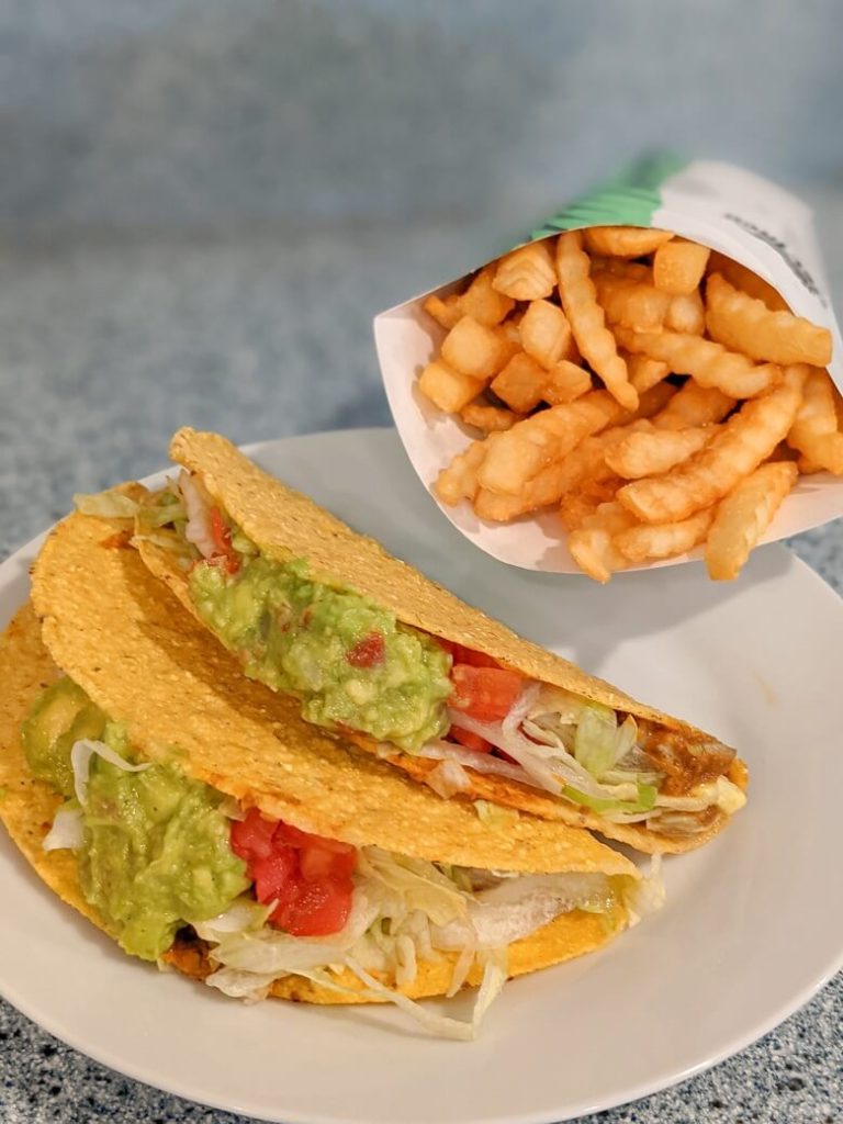 A plate with fries and two Beyond guacamole tacos from Del Taco