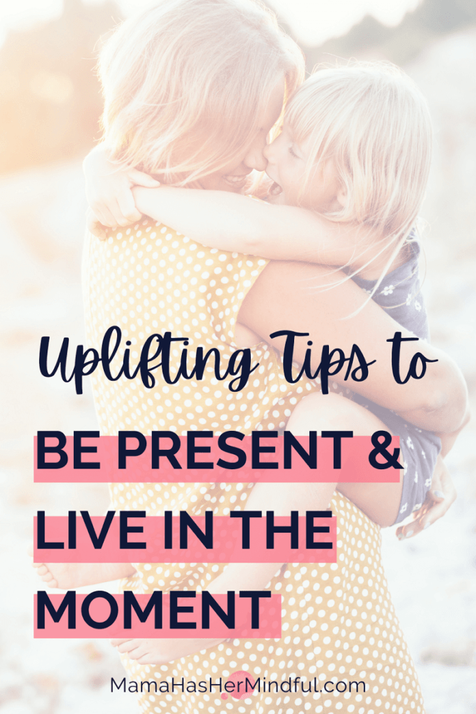 A Pin for Pinterest with a photo of a smiling mother on the beach holding her smiling daughter affectionately. The words "Uplifting Tips to Be Present and Live in the Moment" along with the URL Mama Has Her Mindful dot com appear over the image.